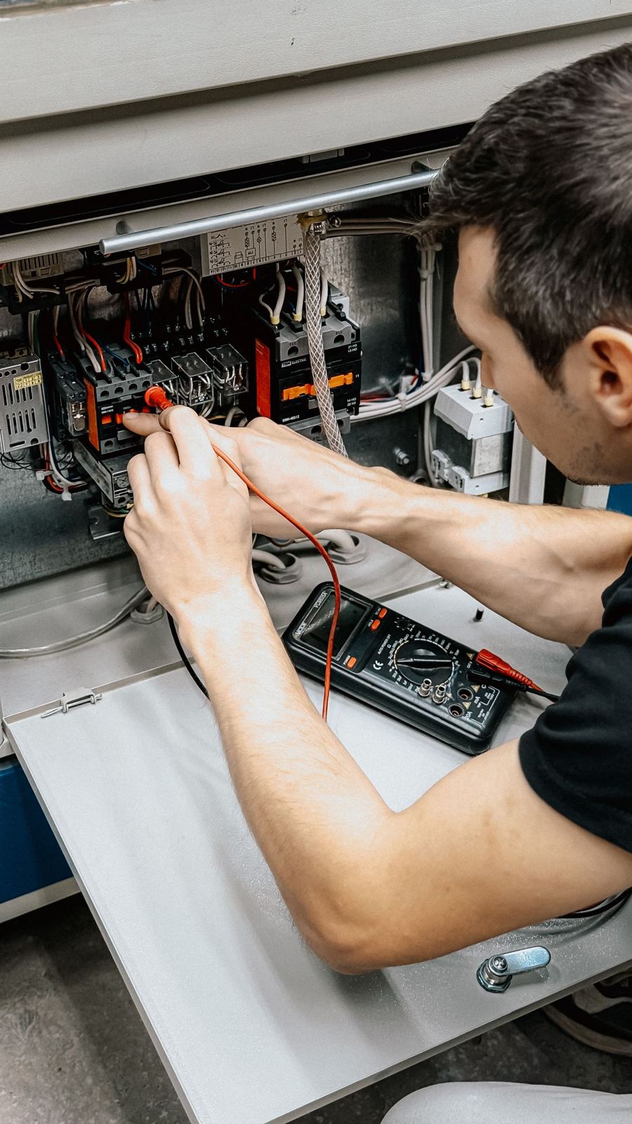 Electrician testing a panel with a multimeter